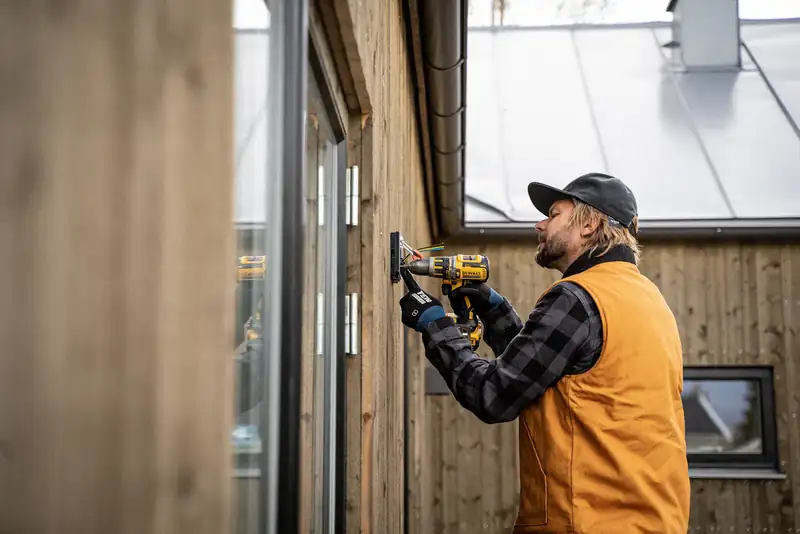 Commercial electrician drilling during an installation