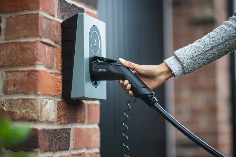 Person charging an electric vehicle at home